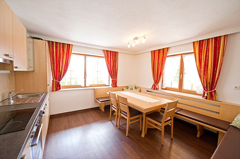Kitchen with a sitting area in apartment 1 of Tiroler Bua